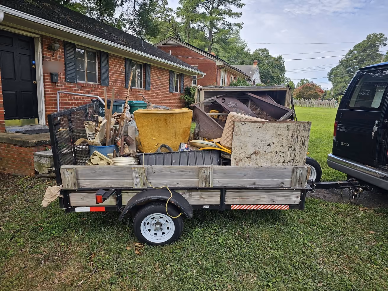 Our trailer loaded with junk in front of a brick house in Richmond, Virginia